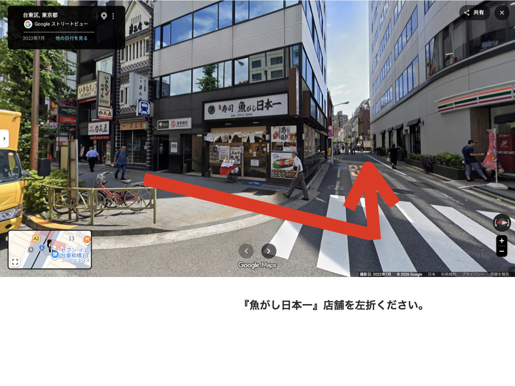 寿司店『魚がし日本一』の店舗前。この角を左折する方向を赤い矢印で示している