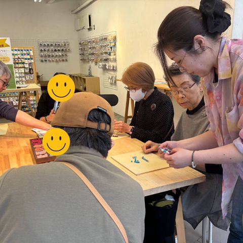 テーブルを囲んでビーズを手に取る参加者